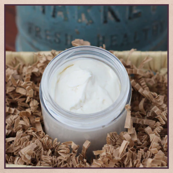 Jar of white cream on a bed of brown shredded paper with a blurred background | Beyond Wellness Collection | Three Mad Hatters, Jackson, MS